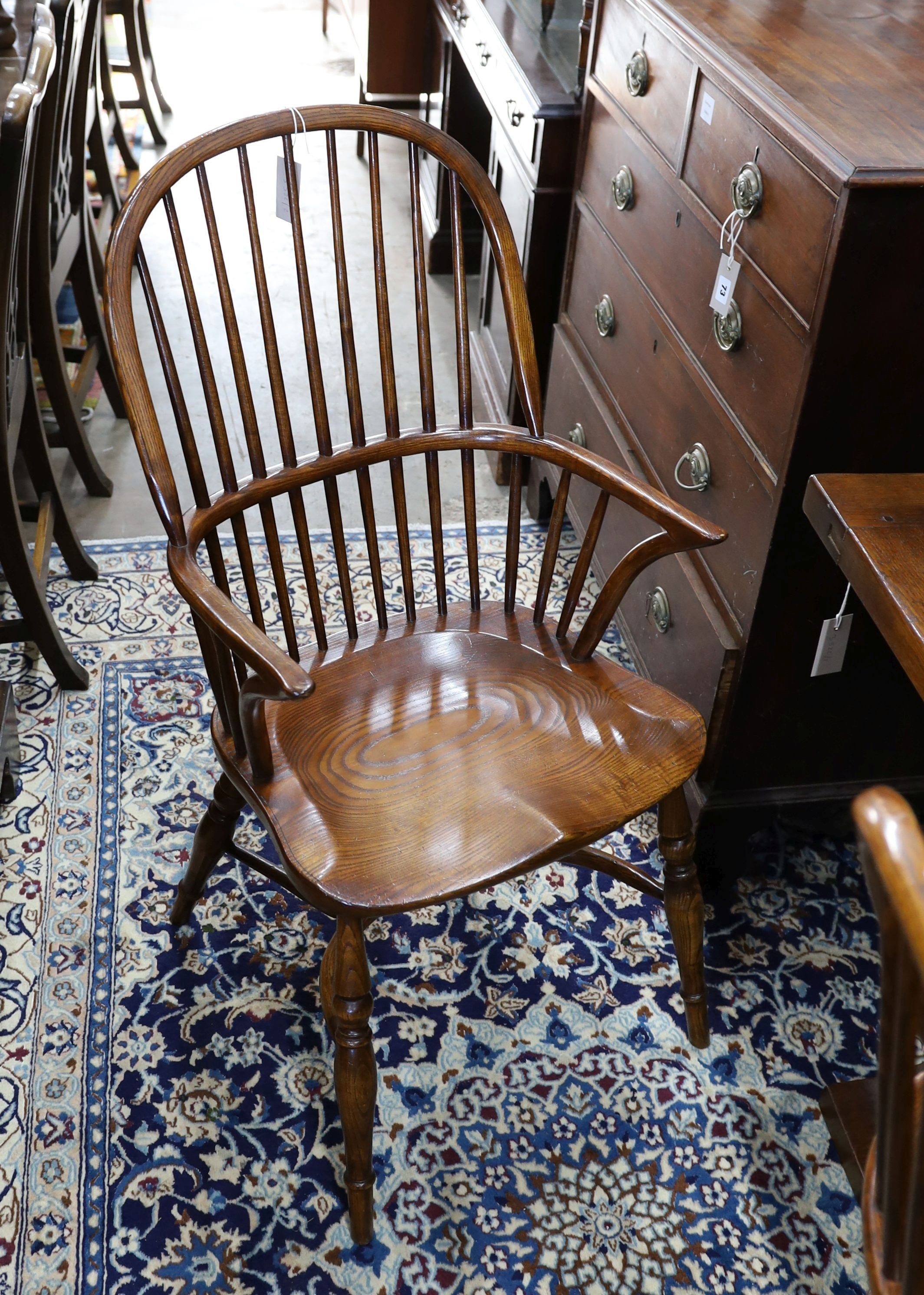 A set of six reproduction ash and elm Windsor comb back armchairs with saddle seats and crinoline stretchers, width 52cm, depth 45cm, height 102cm